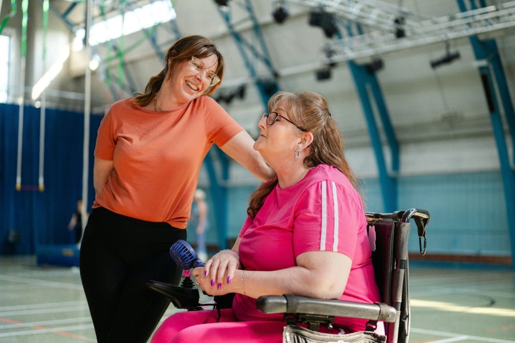 Woman standing next to woman in a wheelchair