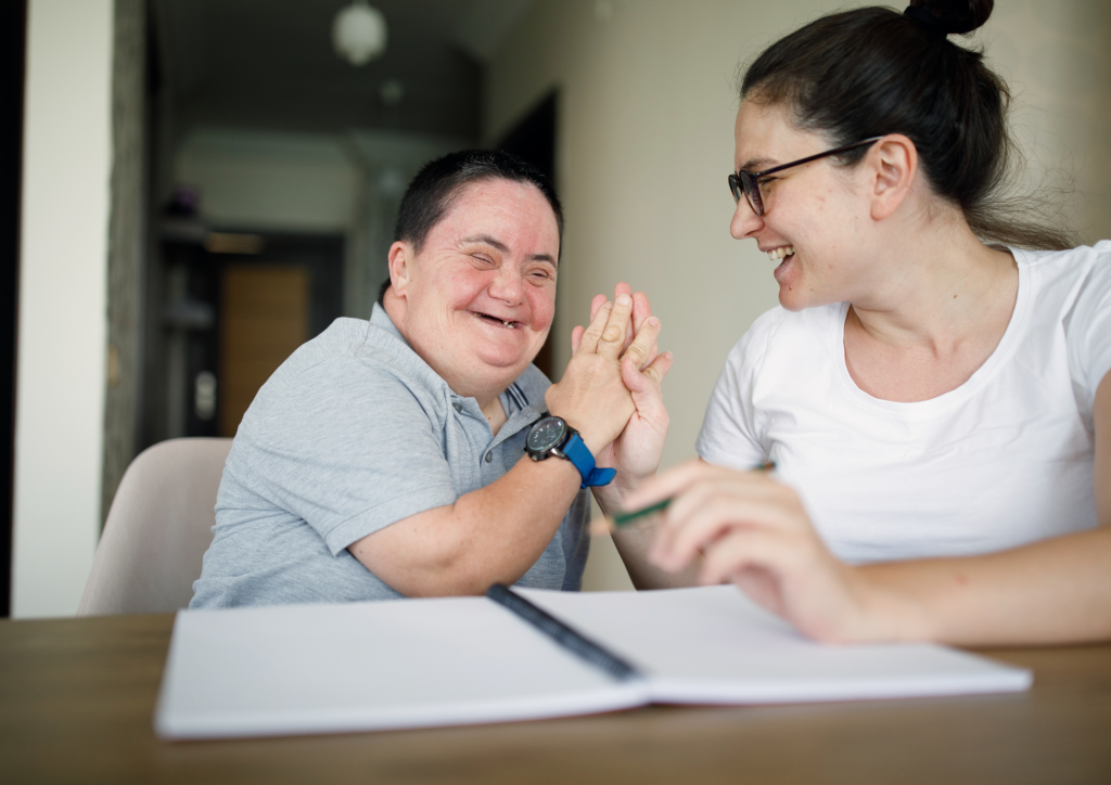 Two people at a desk with a notepad.